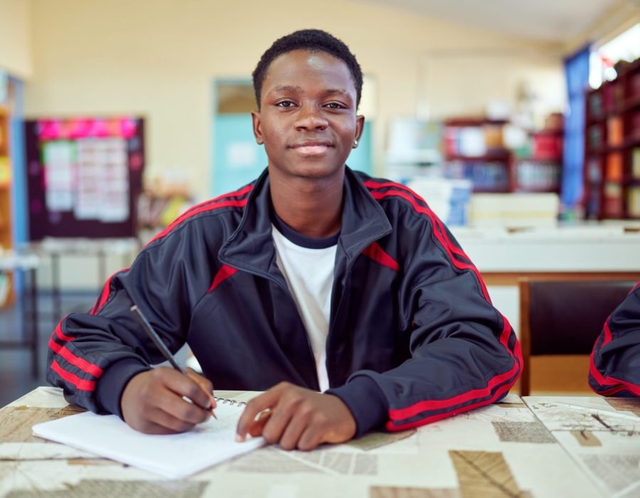 smiling-student-writing-notes-in-classroom-at-scho-2026-01-09-11-05-14-utc (1) (1) (1)